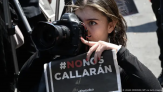 A photographer holds a placard with the hashtag #They Will Not Silence Us, during a sit-in by journalists and members of the Guatemalan Civil Society against the threat to freedom of expression and the criminal prosecution of communicators, outside court in Guatemala City on March 4, 2023