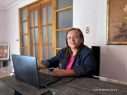 Journalistin Lucia Pineda Ubau sitzt am Computer, im Hintergrund eine Tür.