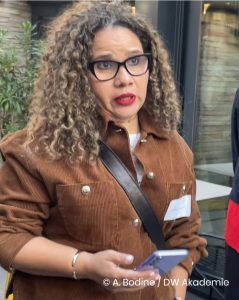 Eine Frau spricht und hält ein Handy in der Hand