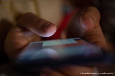 Ein Smartphone wird in Händen gehalten.